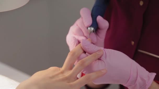 Manicurist klipper naglar med en maskin till en kund i en manikyrsalong. — Stockvideo