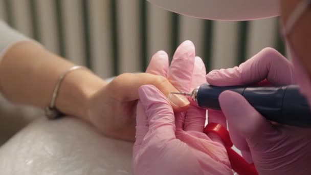 Manicure knipt nagels met een machine naar een klant in een manicure salon. — Stockvideo