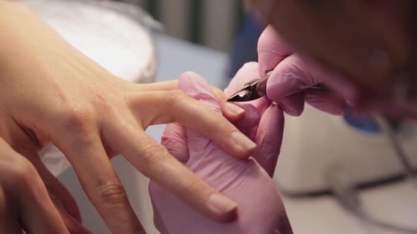 Manicurist tar bort nagelband med pincett. — Stockvideo
