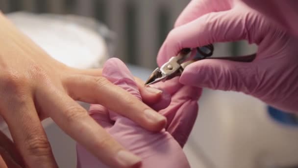 Manicurist tar bort nagelband med pincett. — Stockvideo