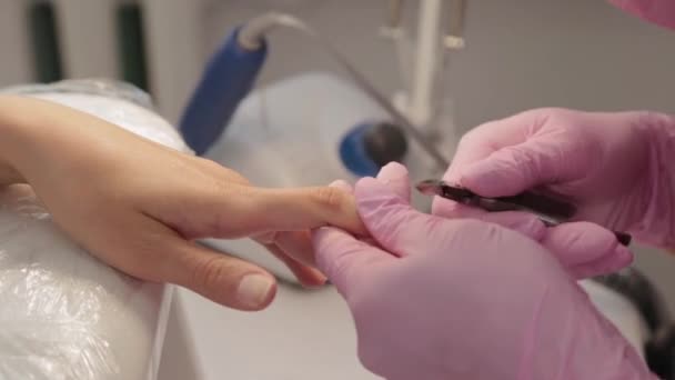 Manicure verwijdert nagelriemen met een tang. — Stockvideo