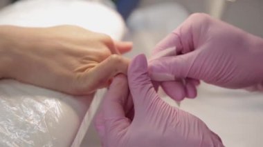 Manikürcü tırnak etlerini forseps ile söker..