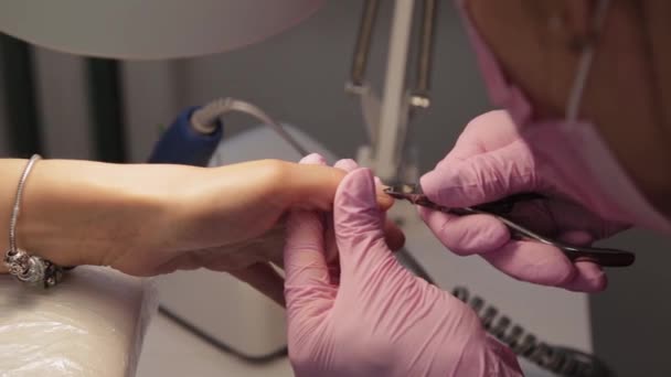 Manicurista elimina cutículas con fórceps . — Vídeo de stock