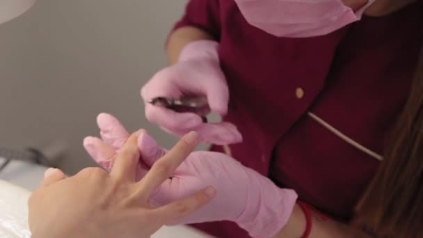 Manicure verwijdert nagelriemen met een tang. — Stockvideo