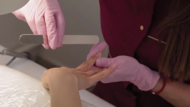 Manikérka stříhá nehty pilníkem na nehty. — Stock video
