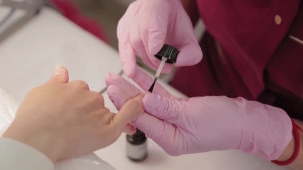 Manicurist polerar naglar med en kund i en skönhetssalong. — Stockvideo