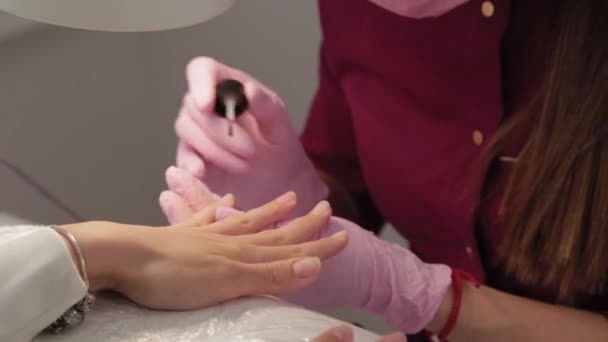 Manicurist polerar naglar med en kund i en skönhetssalong. — Stockvideo