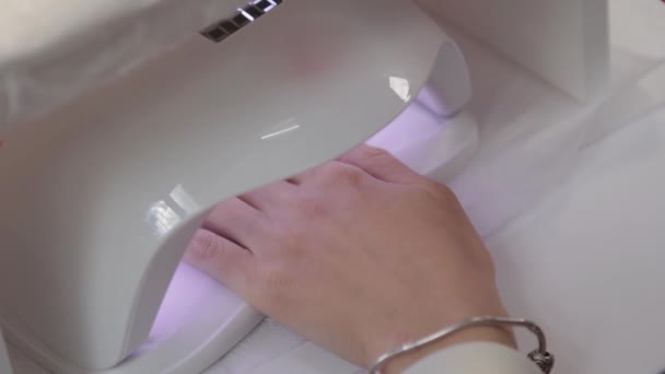 Mulher pinta unhas com gel vermelho polonês em casa sozinho. Uv levou a lâmpada para a manicura de secagem. Método moderno de trabalhar com as mãos. Instrumento ultravioleta, equipamento principal . — Vídeo de Stock