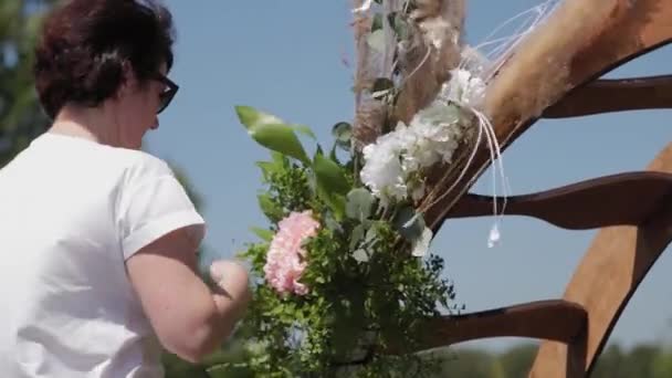 Decorador de casamento decora o lugar de registro de casamento com flores frescas . — Vídeo de Stock