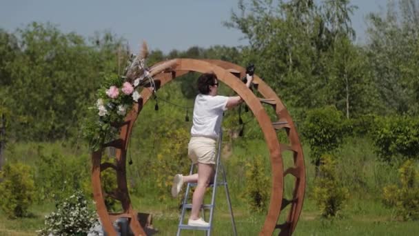 Décorateur de mariage décore le lieu d'enregistrement du mariage avec des fleurs fraîches. — Video