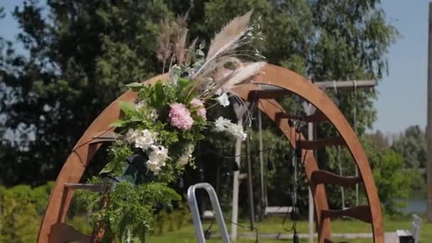 Hochzeitsdekorateur schmückt den Ort der Trauung mit frischen Blumen. — Stockvideo