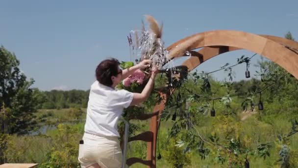 Decorador de casamento decora o lugar de registro de casamento com flores frescas . — Vídeo de Stock