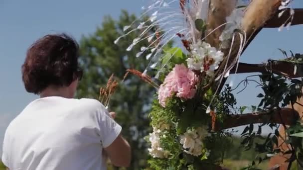 Décorateur de mariage décore le lieu d'enregistrement du mariage avec des fleurs fraîches. — Video