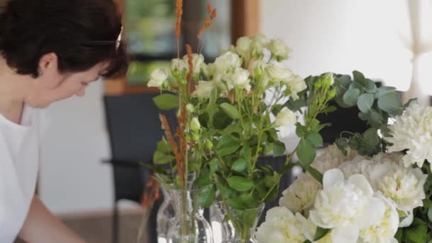 Decorador de bodas decora flores en las mesas . — Vídeo de stock