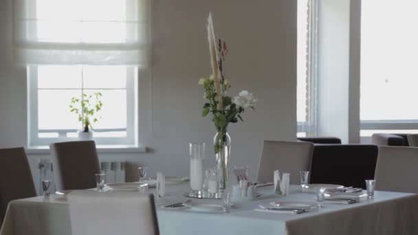 Beautiful flowers in a glass vase on the festive table. — Stock Video