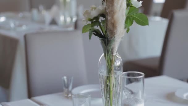 Prachtige bloemen in een glazen vaas op de feestelijke tafel. — Stockvideo