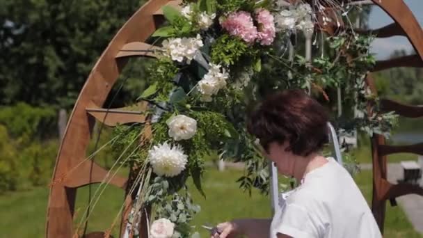 Decorador de casamento decora o lugar de registro de casamento com flores frescas . — Vídeo de Stock