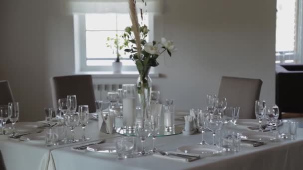 Prachtige bloemen in een glazen vaas op de feestelijke tafel. — Stockvideo