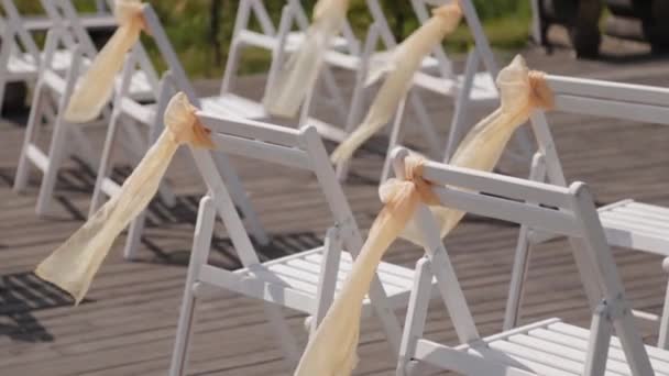 Hermosas sillas con cintas en la recepción de la boda . — Vídeos de Stock