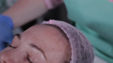 Profesyonel güzellik uzmanı kadın müşteriye şapka takıyor..