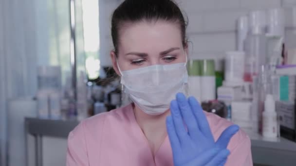 Professionell kosmetolog sätter på gummihandskar före ingreppet. — Stockvideo