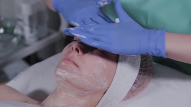 Esteticista profesional lava a una mujer y masajea su cara . — Vídeos de Stock