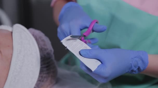 Beautician cuts a bag with serum. — Stock Video