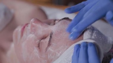 Profesyonel bir güzellik uzmanı bir kadına yüz masajı yapar. Kozmetoloji.
