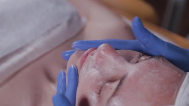 Profesjonalny kosmetyk robi kobiecie masaż twarzy. Kosmetologia. — Wideo stockowe