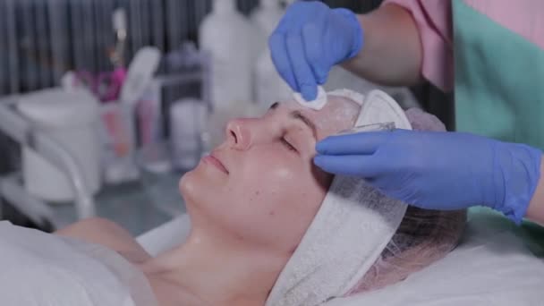 Beautician εφαρμόζει ταλκ σε σκόνη στο πρόσωπο της γυναίκας. — Αρχείο Βίντεο