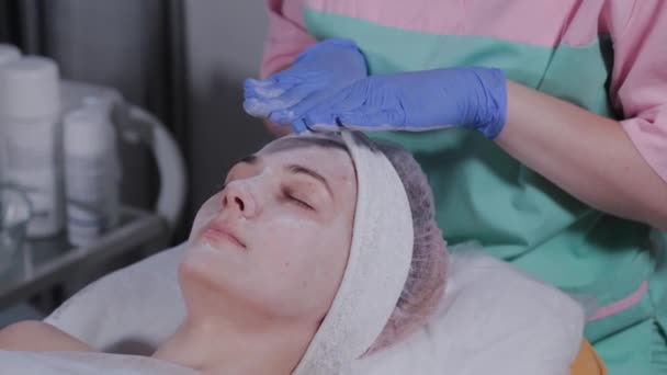Esteticista hace masaje facial a una mujer en un salón de belleza . — Vídeos de Stock