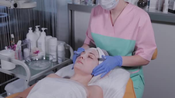 Kosmetička dělá masáž obličeje na ženu v salónu krásy. — Stock video