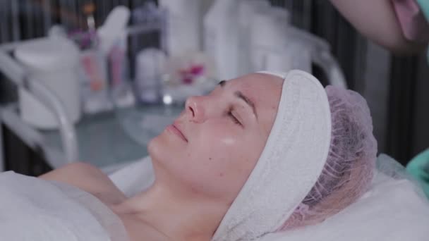 Estetista professionista che applica una maschera viso a una donna . — Video Stock