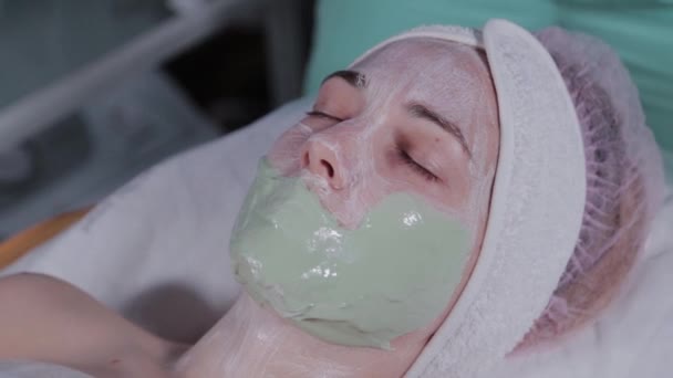 Profesional aplica una máscara facial a una mujer . — Vídeos de Stock