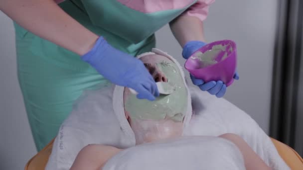 Profissional aplica uma máscara facial a uma mulher . — Vídeo de Stock