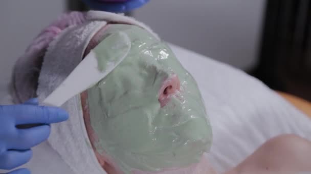 Επαγγελματίας εφαρμόζει μάσκα προσώπου σε μια γυναίκα. — Αρχείο Βίντεο