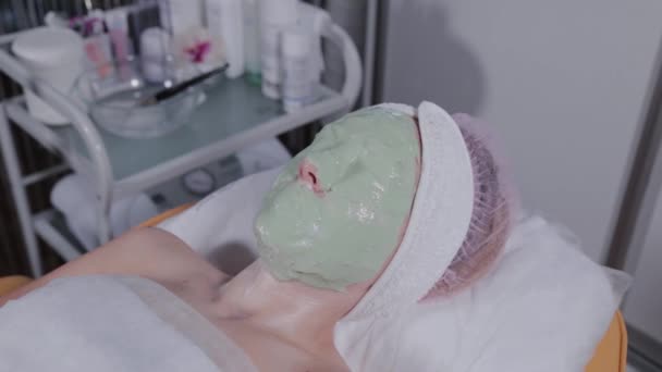Beautiful woman with cosmetology face mask. — Stock Video