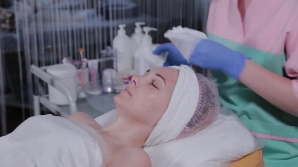 Ahli kecantikan profesional mencuci topeng dari wajah seorang wanita.. — Stok Video