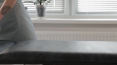 Güzellik uzmanı kumaşı kanepeye sarar..