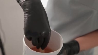 Kozmetikçi kavanozdaki şeker macununu alıyor. Shugaring. Konteynırdan bir spatula ile şeker ezmesi. Şekerleme için şeker ezmesi. Güzellik salonunda şekerleme.