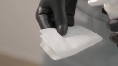 Güzellik uzmanı peçeteye sıvı sürüyor..