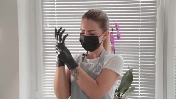 Beautician se pone guantes de goma negros en las manos . — Vídeos de Stock