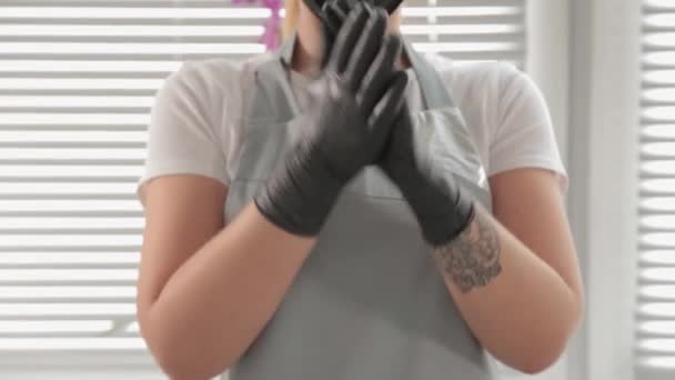 Beautician disinfects rubber black gloves. — Stock Video