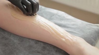 Güzellik uzmanı genç bir kadının bacaklarında titreme yapar..