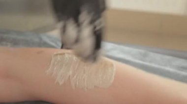 Güzellik uzmanı genç bir kadının bacaklarında titreme yapar..