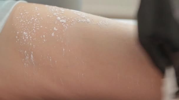 Косметолог робить шугарінг на ногах молодої жінки . — стокове відео