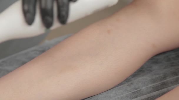Estetista prepara le gambe di una giovane donna per shugaring. — Video Stock