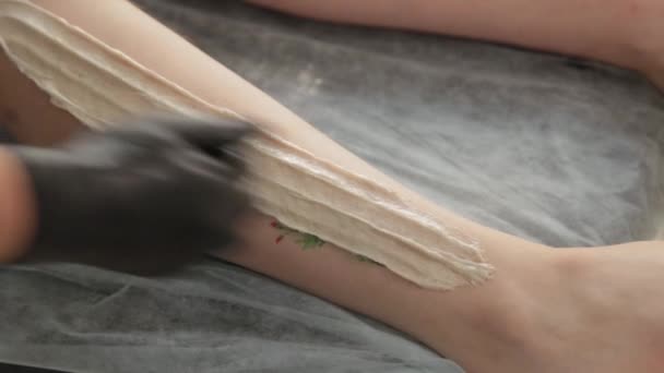 Красавчик делает шугаринг на ногах молодой женщины . — стоковое видео