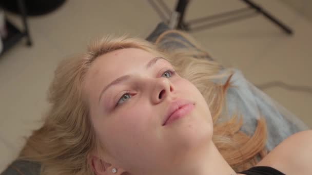 Junge Frau über den Eingriff bei der Kosmetikerin. — Stockvideo