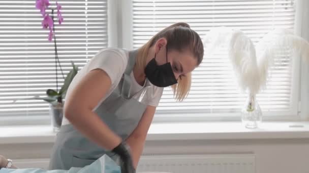 Schoonheidsspecialiste in een masker aan het werk in een schoonheidssalon. — Stockvideo